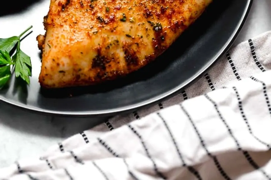 Blancs de poulet dorés aux épices, tranchés sur une planche